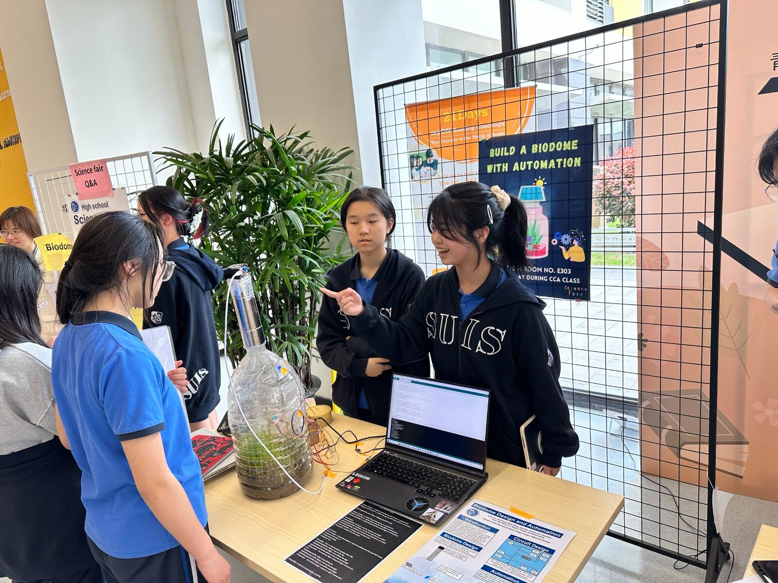 Students presenting biodome at school science fair
