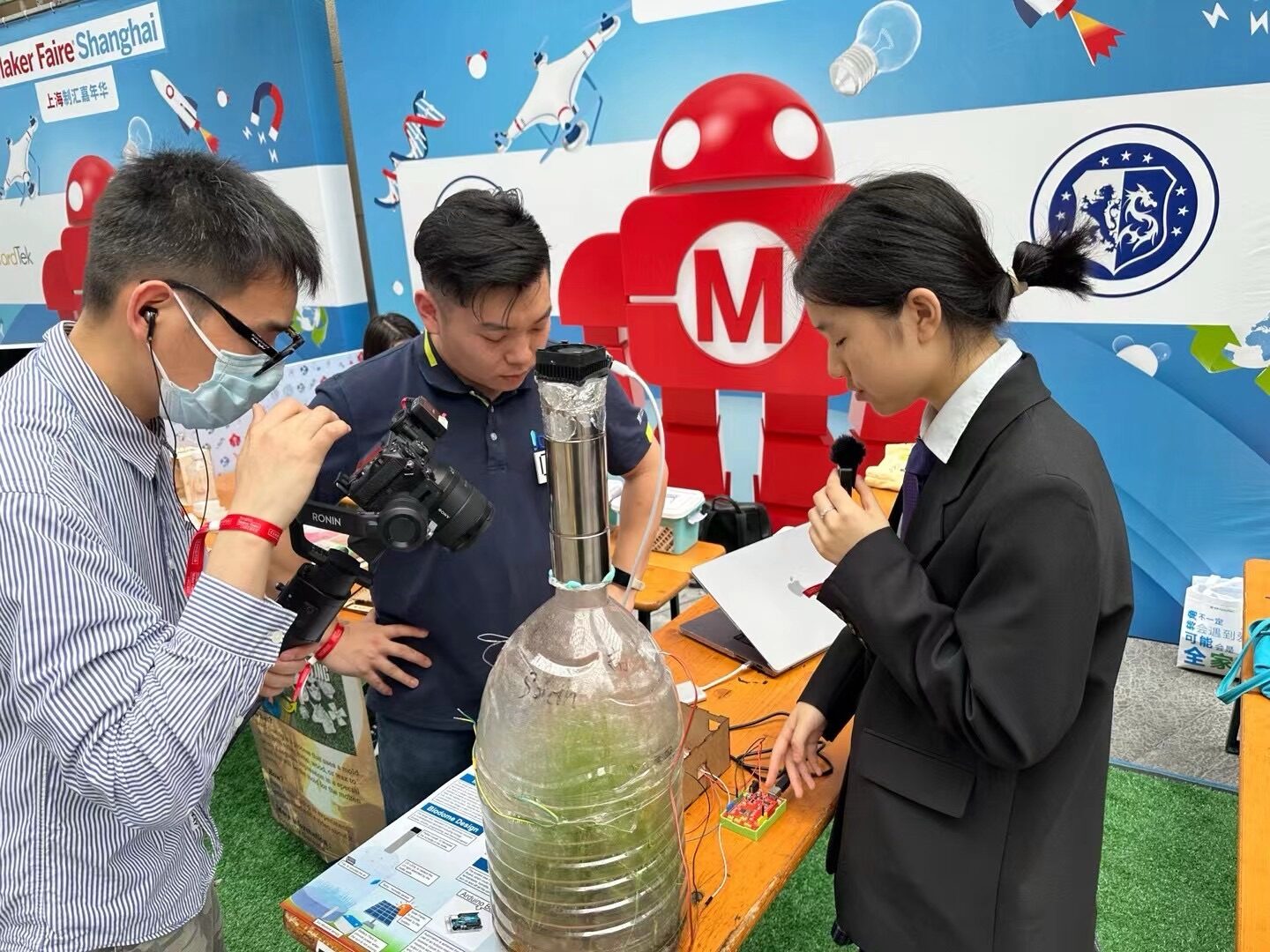 Student being interviewed by media about biodome project at Maker Faire