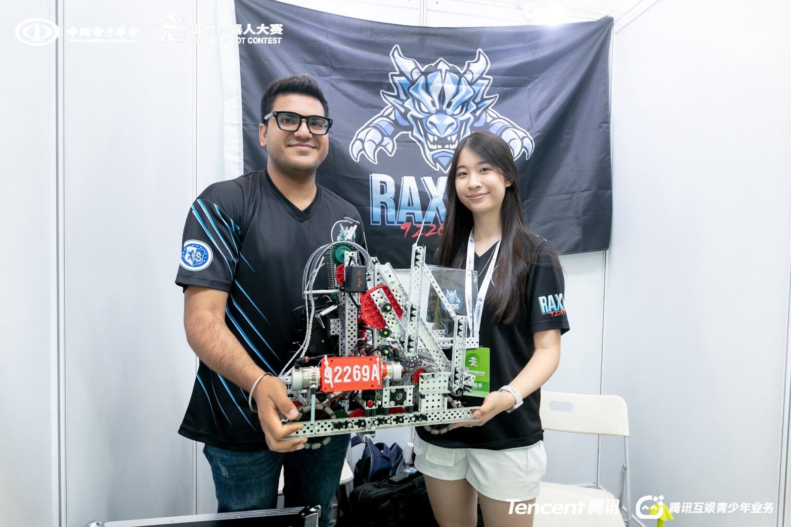 Robotics coach Sushil Lamba with student and competition VEX robot at World Robot Contest